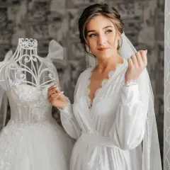 Panna młoda w białej szacie, obok sukni ślubnej na manekinie. Czyżby ślub w maju przesądy nie były jej straszne?