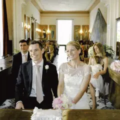 Para młoda uśmiecha się, choć w tle widać tylko kilka osób. Może to znak, że nie mam świadków na ślub, ale miłość jest najważniejsza.