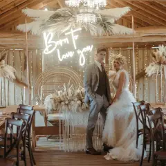 Eleganckie wesele w stodole: boho dekoracje z traw pampasowych, neon "Born to love you" i para młoda.