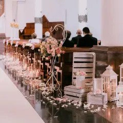 Elegancka dekoracja kościoła na ślub: mnóstwo świec, płatków róż i kwiatów. Zastanawiasz się, ile kosztuje dekoracja kościoła na ślub?