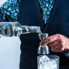 Barman nalewa Żubrówkę do kieliszka z lodem. Idealny wybór na wesele, jeśli szukasz czegoś mocniejszego niż wina na wesele ranking.