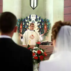 Ślub w kościele. Ksiądz udziela błogosławieństwa parze młodej. Czy świadkami na ślubie mogą być dwie kobiety? Tak, to możliwe.