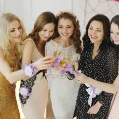 Pięć kobiet wznosi toast kieliszkami szampana. Wszyscy mają na sobie opaski z napisem "Panieńskie". To idealny moment na krótkie życzenia na panieński!