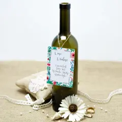 Butelka wina z etykietą "Wino Weselne" i ozdobami. Może to być prezent, który zawiera śmieszne wierszyki na wesele za flaszkę.