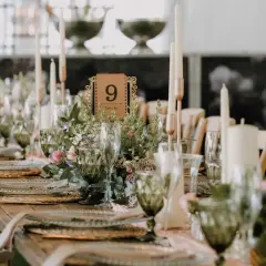 Piękne wesele w stylu boho. Długi stół z rustykalnymi dekoracjami, świecami i kwiatami. Numer stołu 9.