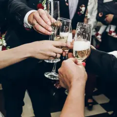 Wznoszenie toastu szampanem na weselu. Radość i celebracja, a także odpowiedź na pytanie: ile napoi na wesele?