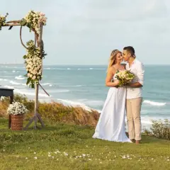Para Młoda na tle morza, piękny ślub na plaży w Polsce. Ceremonia pod kwiecistym łukiem, romantyczna atmosfera.