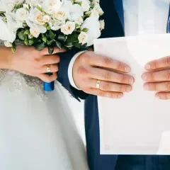 Para młoda trzyma bukiet i dokument. Zastanawiasz się, ile powinna dać świadkowa na wesele?