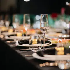 Elegancko nakryty stół weselny, szkło i talerzyki czekają na gości.