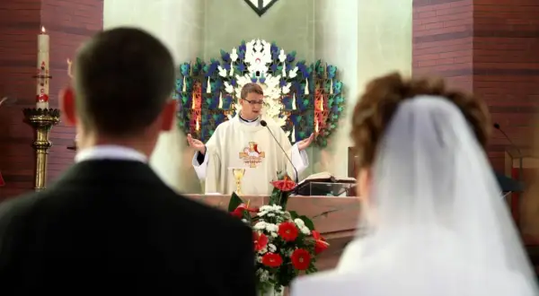 Ślub w kościele. Ksiądz udziela błogosławieństwa parze młodej. Czy świadkami na ślubie mogą być dwie kobiety? Tak, to możliwe.