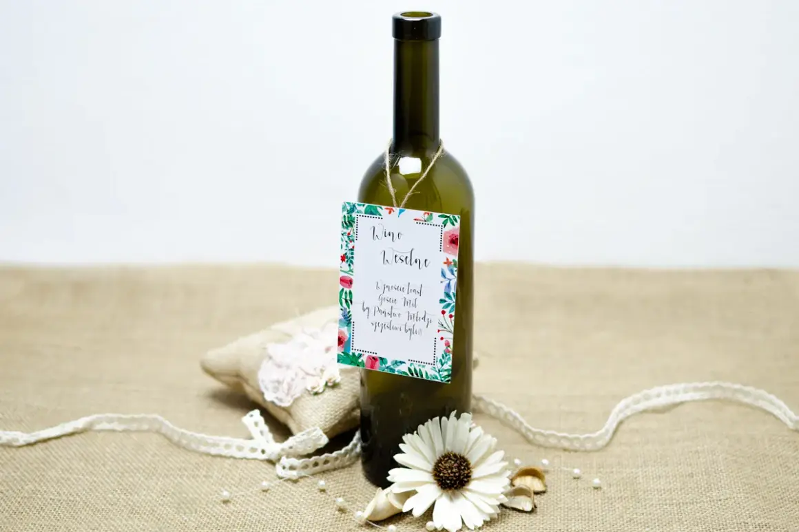 Butelka wina z etykietą "Wino Weselne" i ozdobami. Może to być prezent, który zawiera śmieszne wierszyki na wesele za flaszkę.