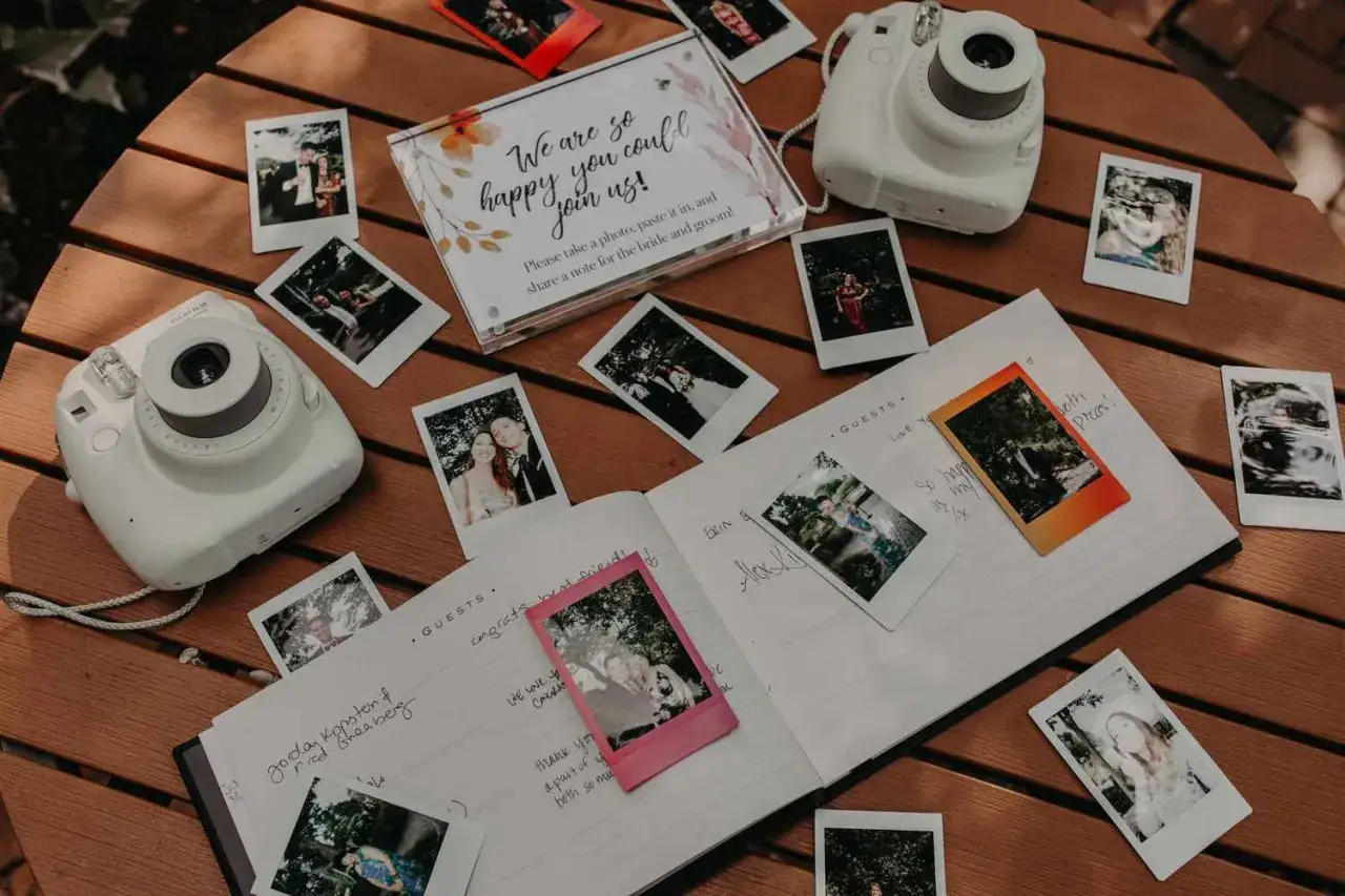 Instax na weselu: aparat i księga gości z polaroidami, na których widać pary młode i innych gości.