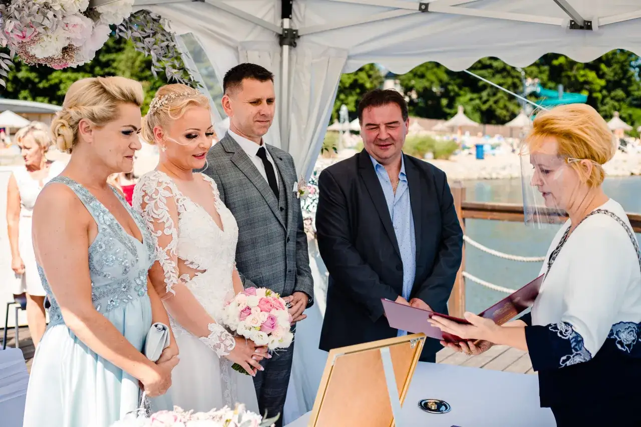 Para ślubna, świadkowie i urzędniczka podczas ceremonii. Czy rodzice mogą być świadkami na ślubie cywilnym? Tak, jak widać na zdjęciu.