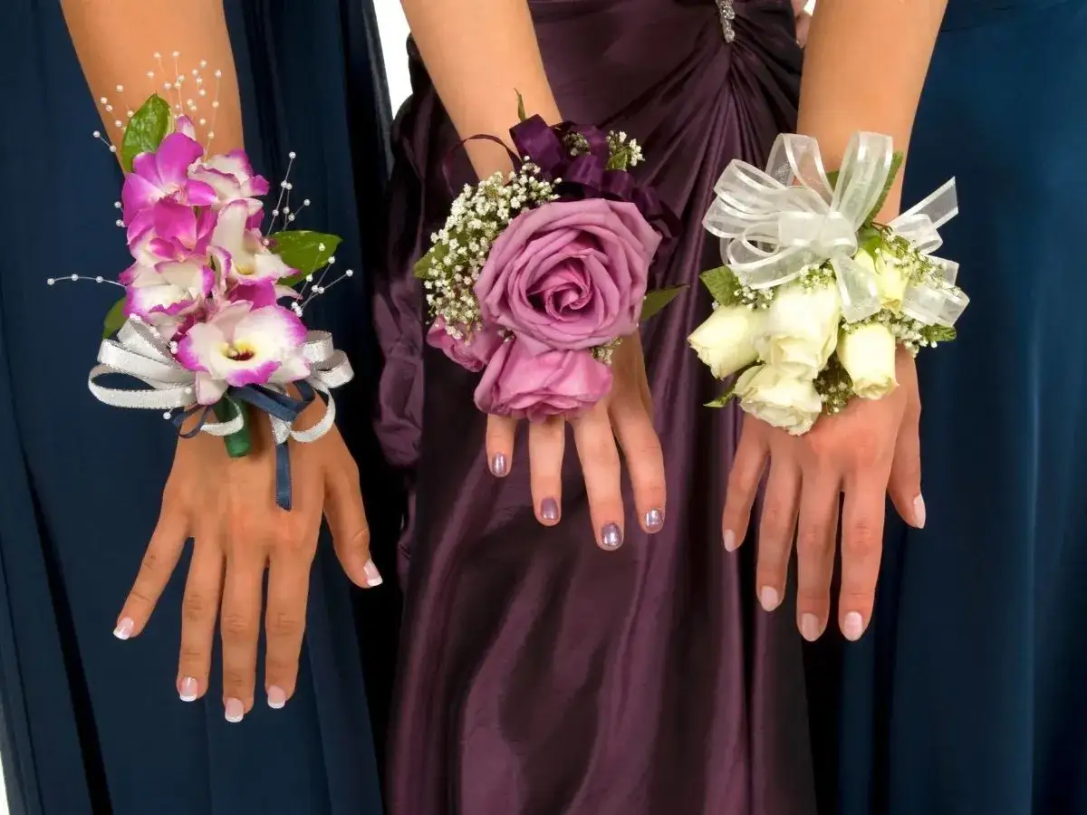 Trzy eleganckie korsarze dla świadkowej: różowe orchidee, fioletowa róża i bukiecik białych róż, ozdobione wstążkami i perełkami.