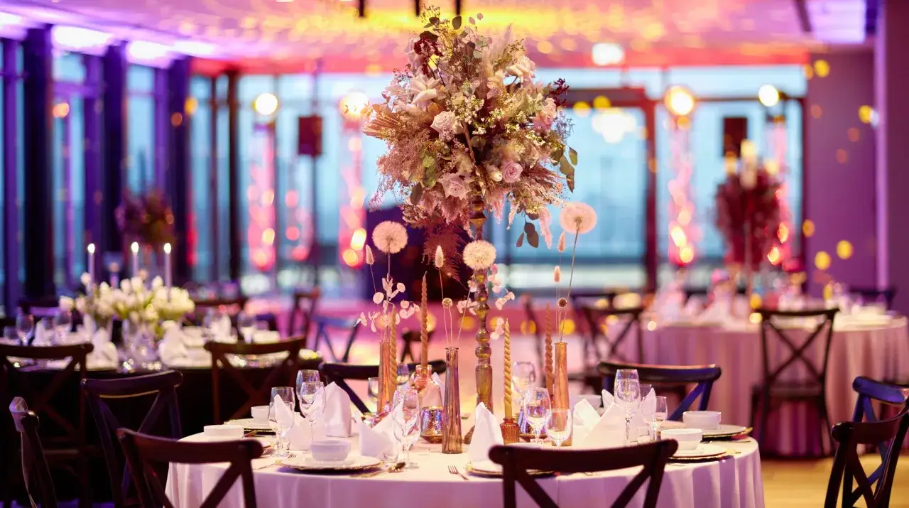Elegancka sala weselna z kwiatami i świecami. Zastanawiasz się, ile kosztuje udekorowanie sali weselnej?
