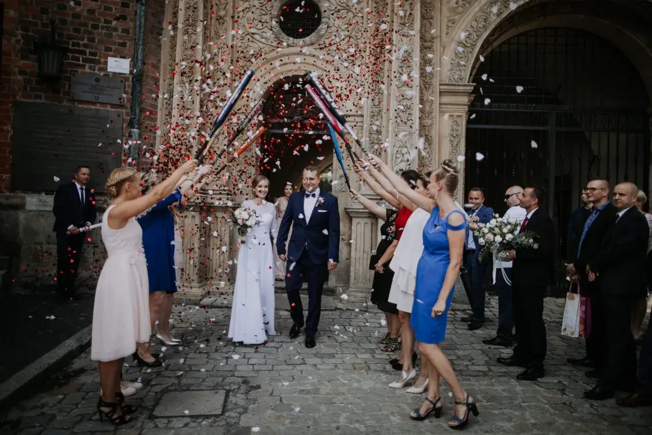Szczęśliwe wyjście z kościoła pary młodej, obsypanej płatkami róż.