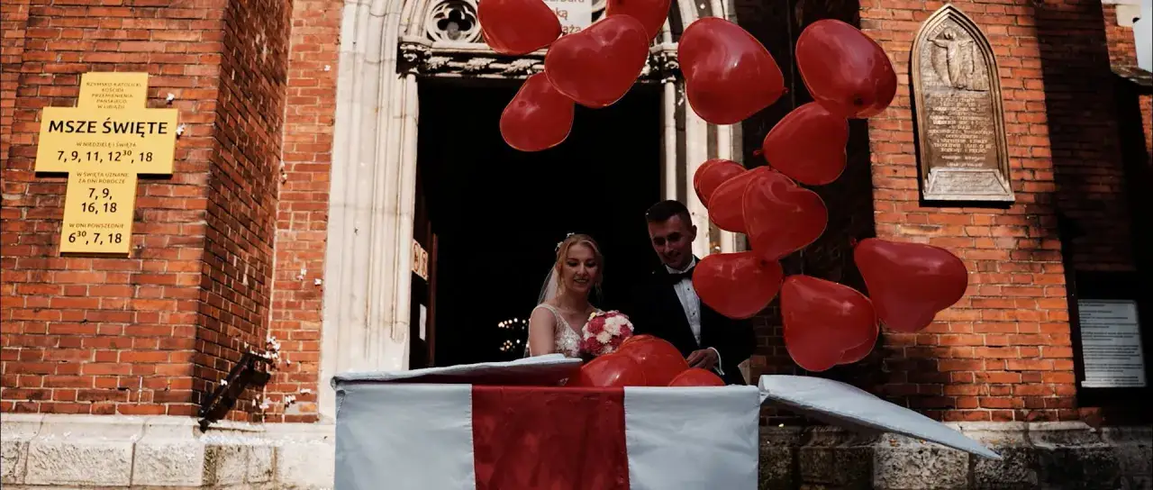 Para młoda wyskakuje z pudełka, a czerwone balony w kształcie serc unoszą się w powietrzu. To wspaniała niespodzianka na wesele!