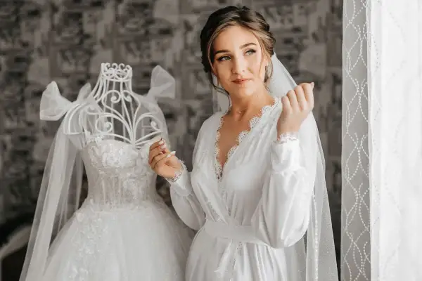 Panna młoda w białej szacie, obok sukni ślubnej na manekinie. Czyżby ślub w maju przesądy nie były jej straszne?